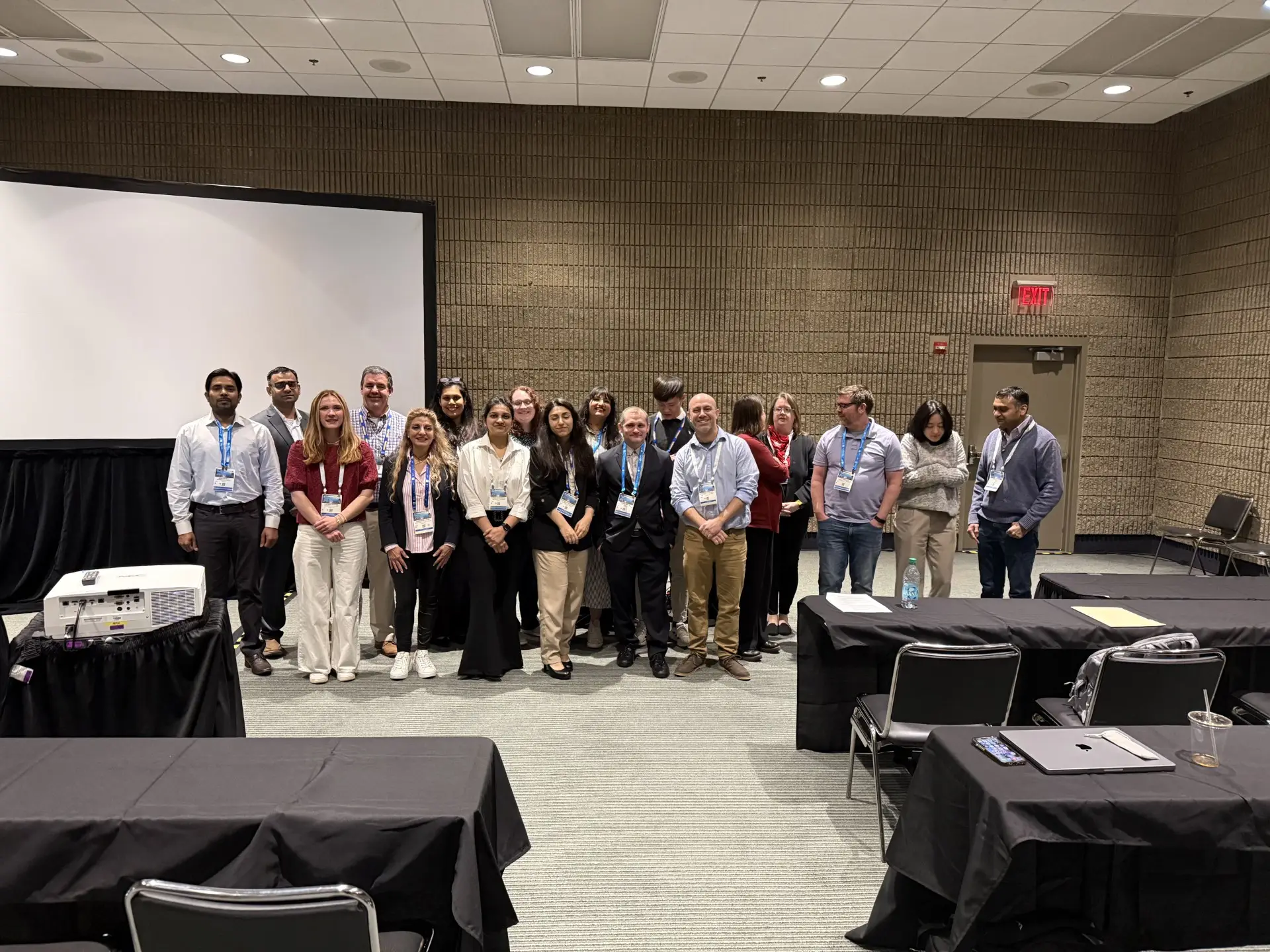 Members of the BioF:GREAT team standing together in front of the projection screen in an ACS Spring 2026 session room.